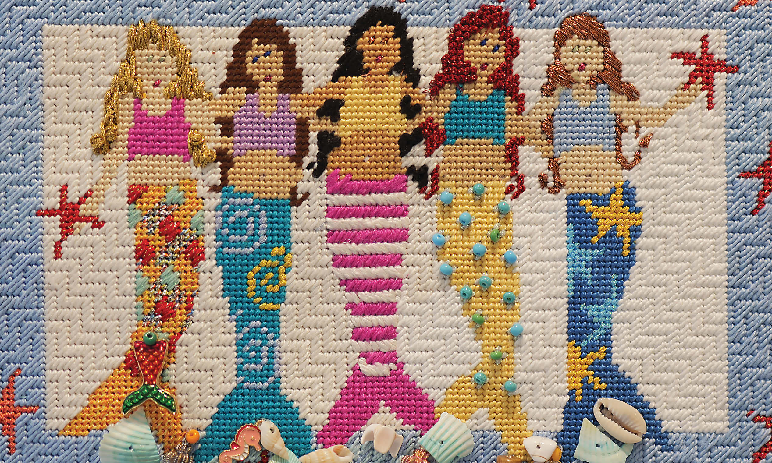 Cross stitch artwork of mermaids