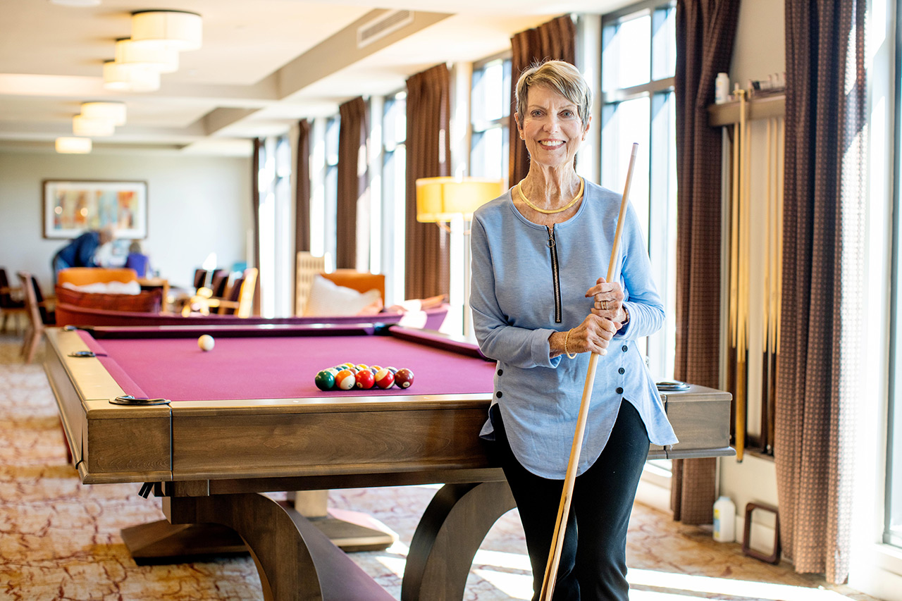 woman standing in front of pool table
