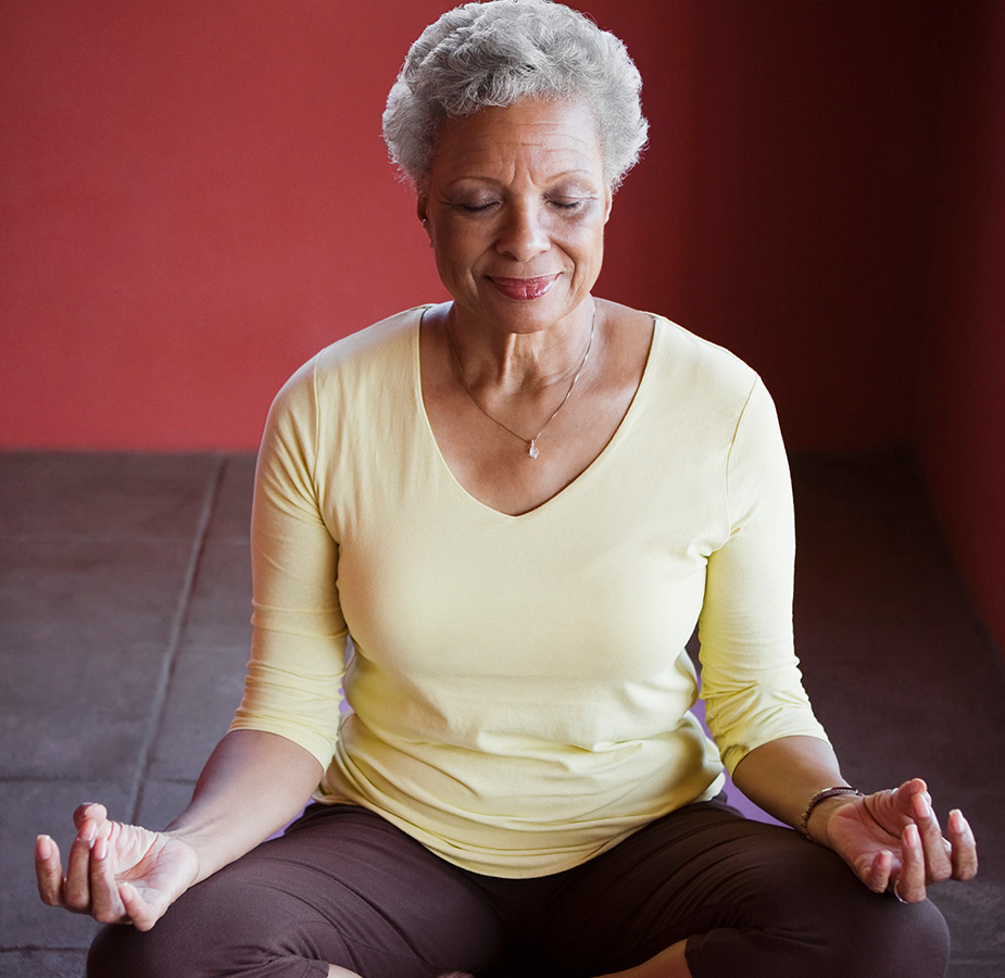 elderly woman in namaste pose