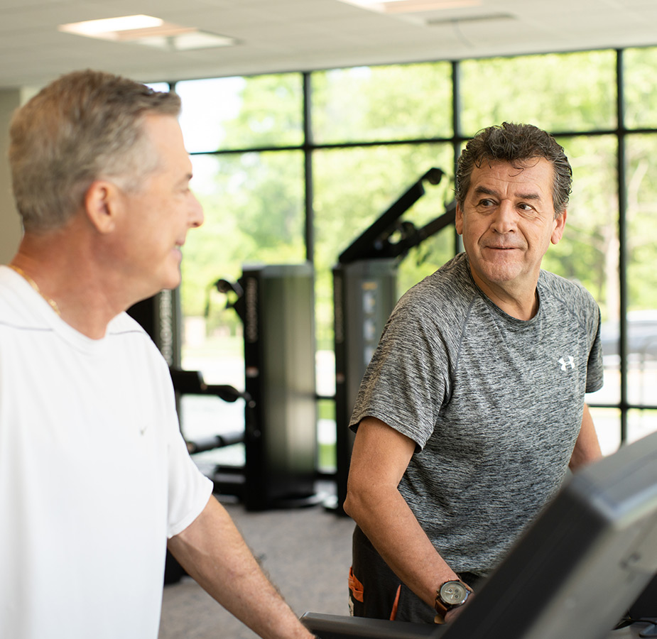 Two people on the treadmills at the fitness center.