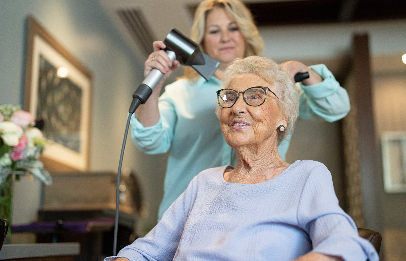 resident having her hair blow dried and styled at salon