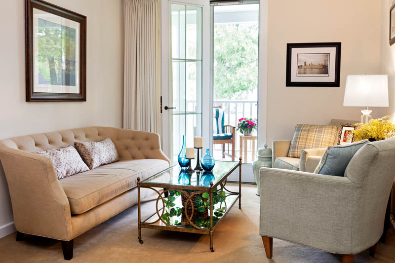 Furnished living room space with sofas, table, and balcony.