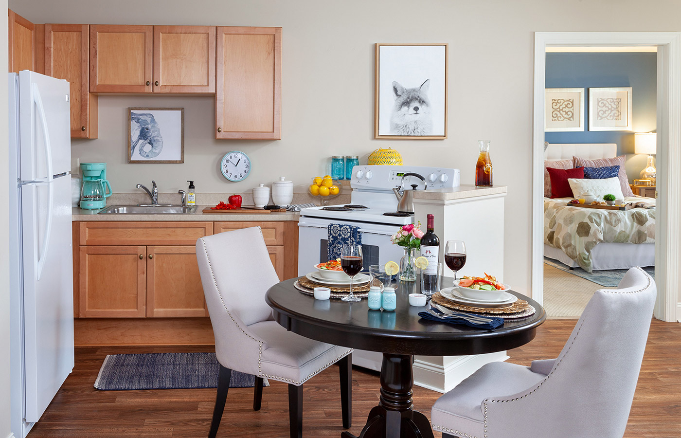 Furnished kitchen with table, cabinets, and refrigerator.