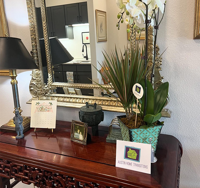 A desk with a lamp and plant on it.