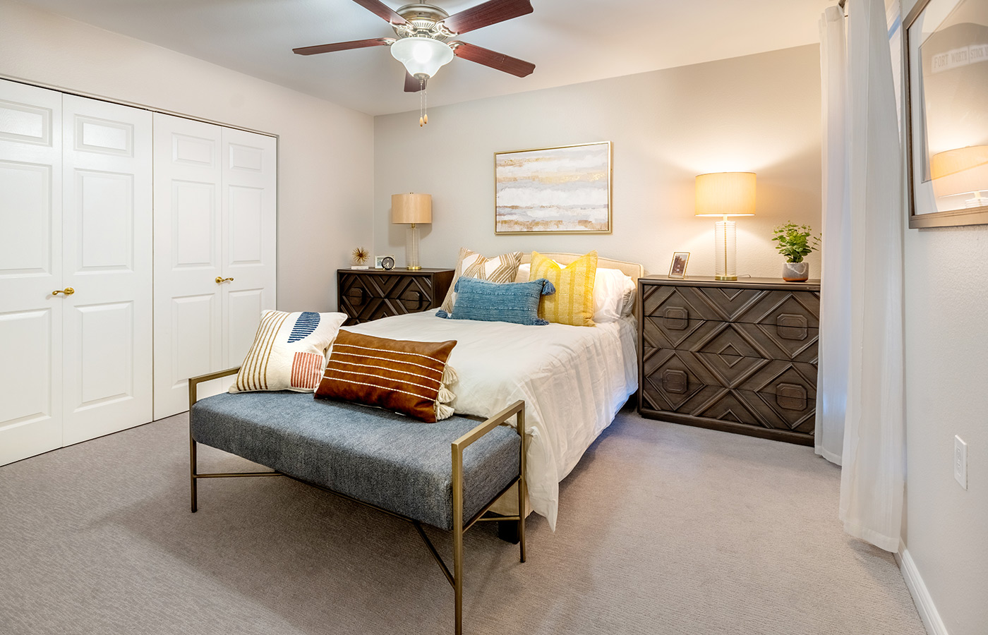 Model bedroom with a bed and dresser. 