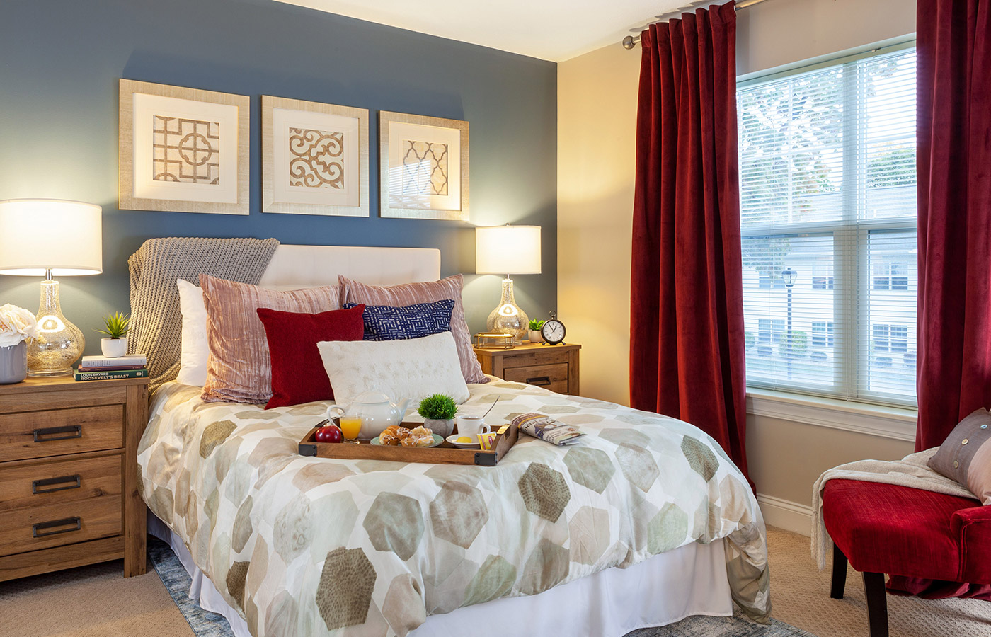 Furnished bedroom with bed, drawers, and soft lighting.