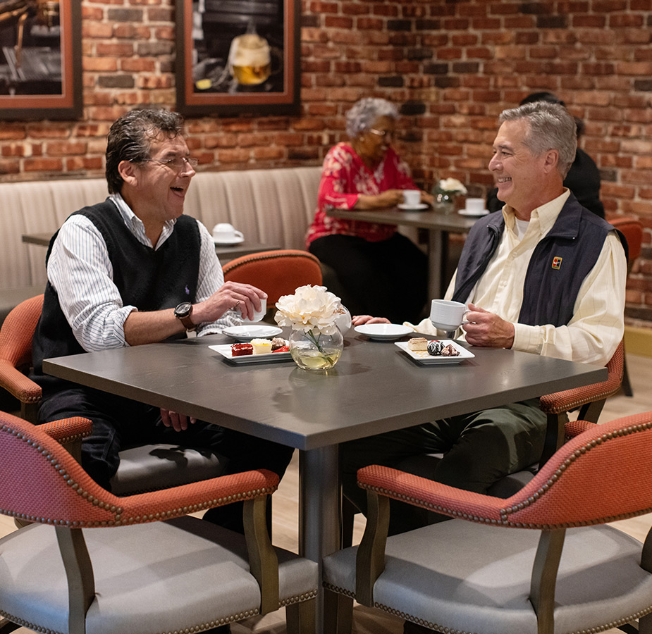 Two friends at a table having coffee.