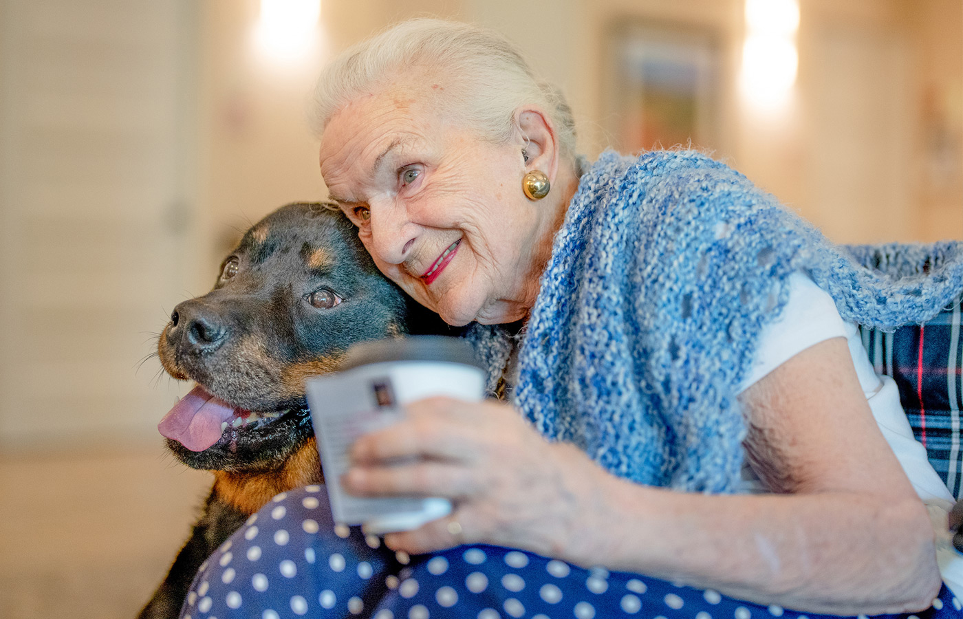 an elderly woman hugging her dog