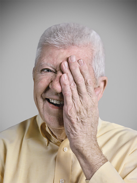 A person covering one eye and smiling.