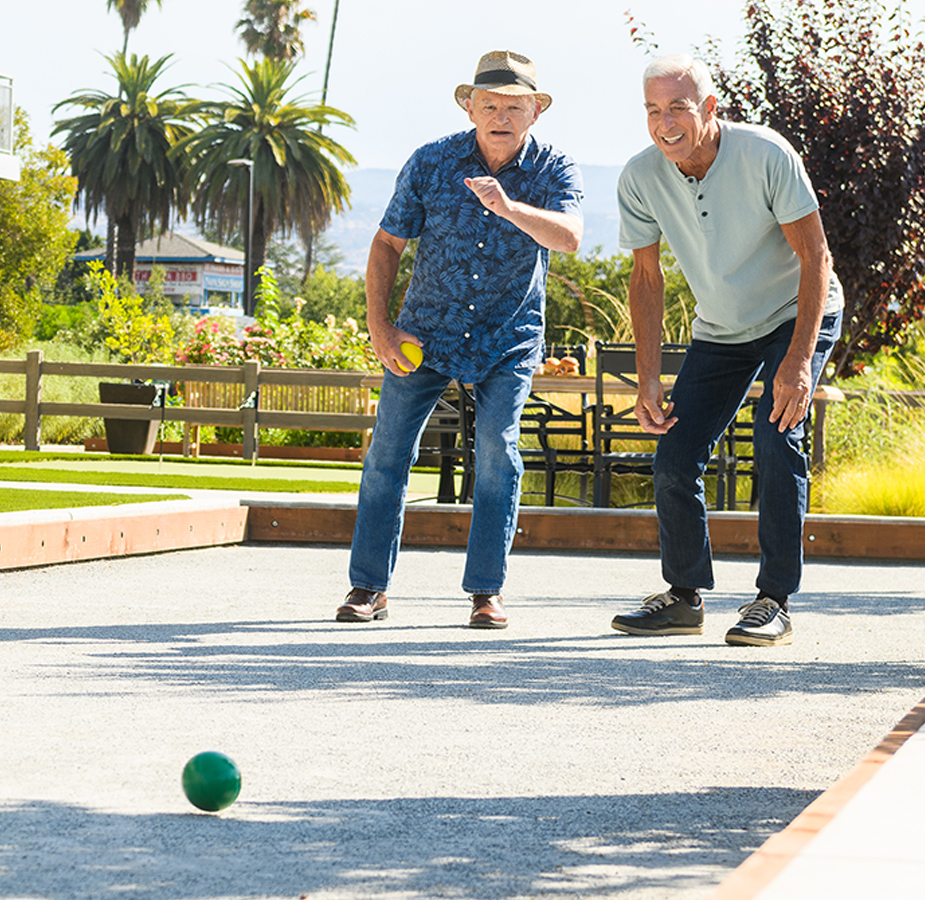 Two residents are playing bocce ball.