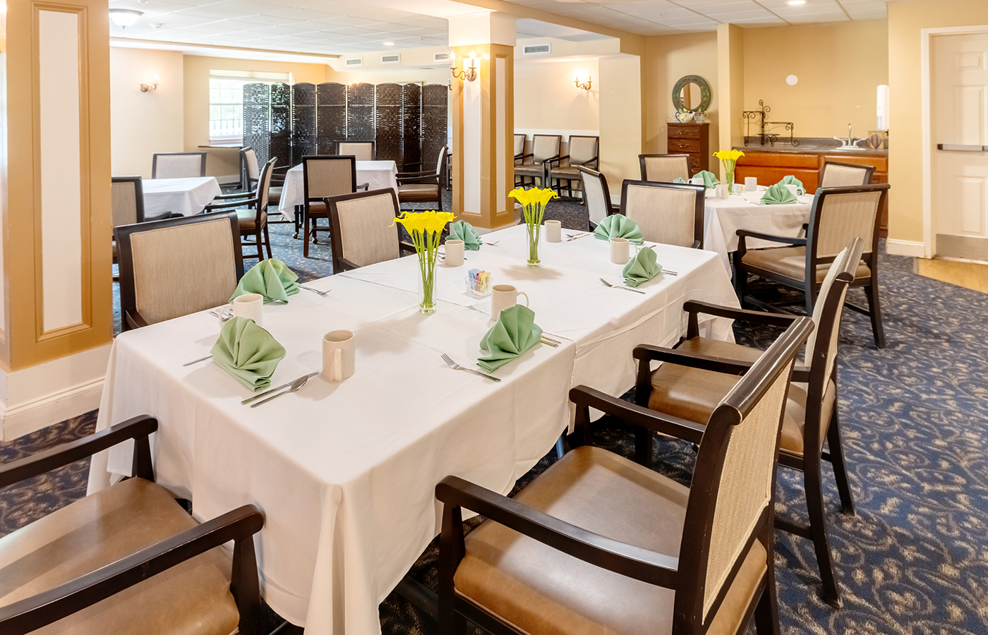 A dining room with flowers on the table.