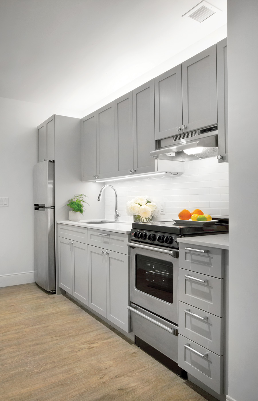 Furnished kitchen with cabinets and refrigerator.