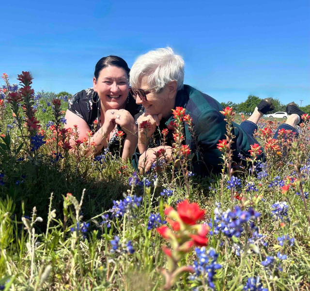 NVN-hand-in-hand Two people laying in field of flowers