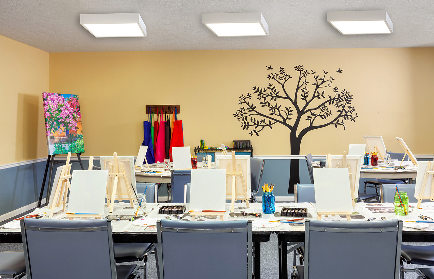 Art room with canvases and paints on table.