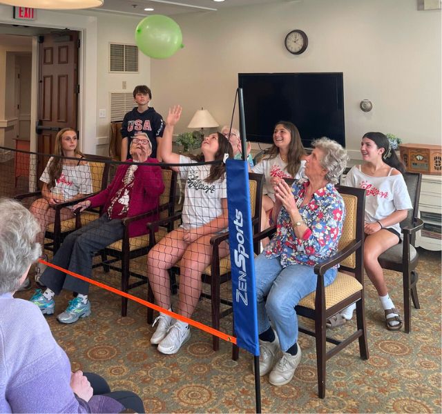 MLB-vollyball Residents and students playing volleyball with a balloon.