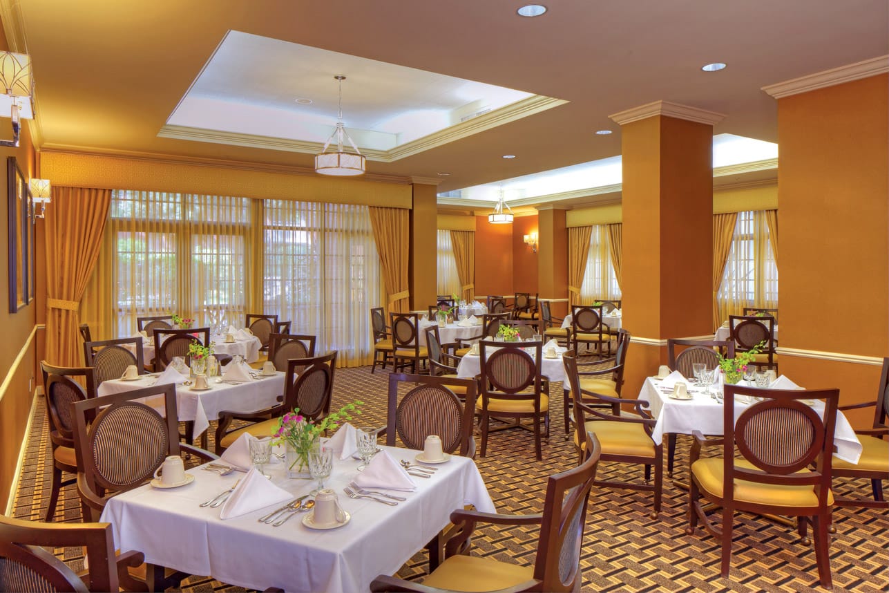 large dining area with set tables and white tablecloths