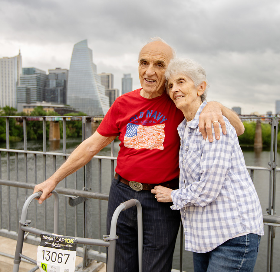 A couple outside with a cityscape behind them.