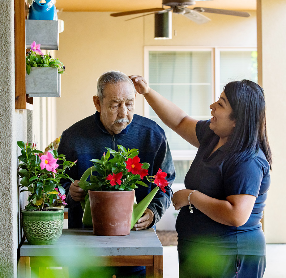 A naya caregiver helping a resident in the garden.