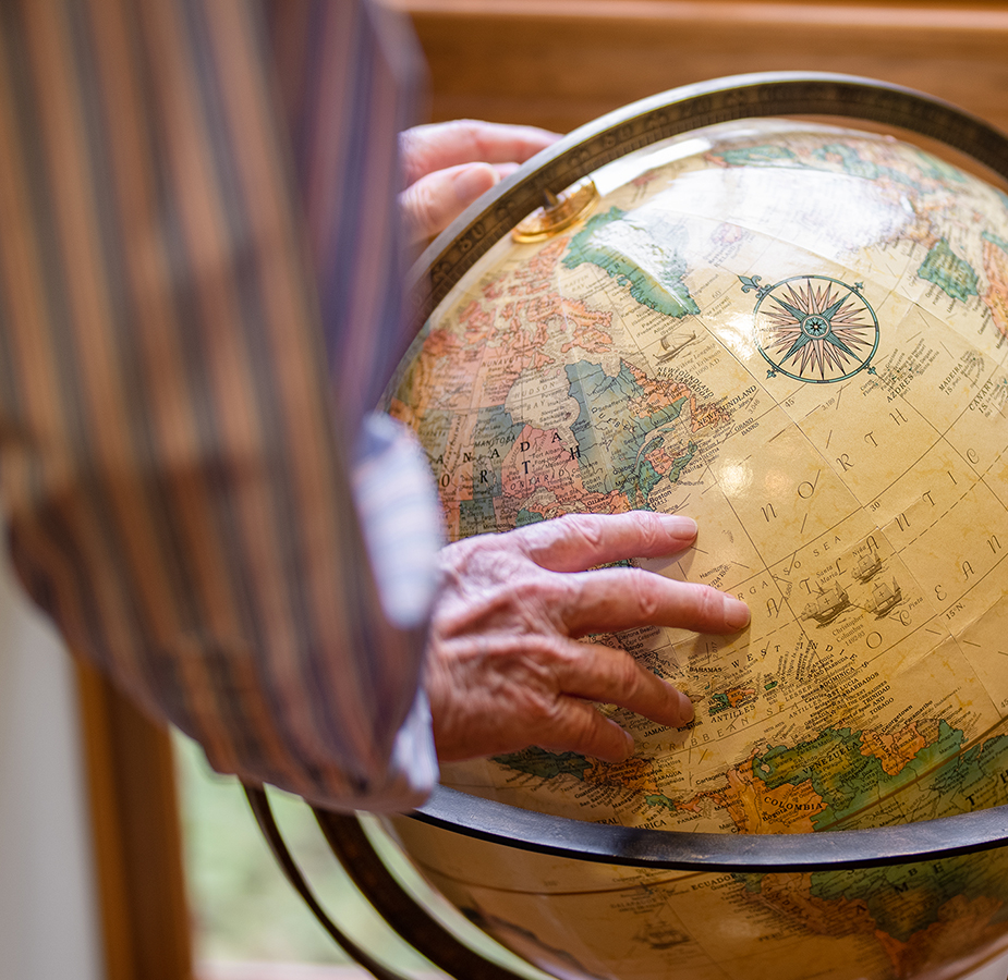 a close up of a man spinning an Earth globe