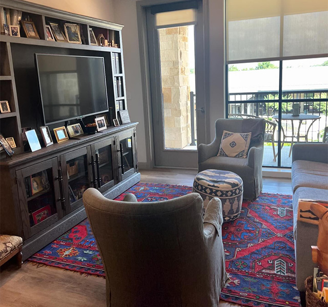 A living room with seating and a large tv.
