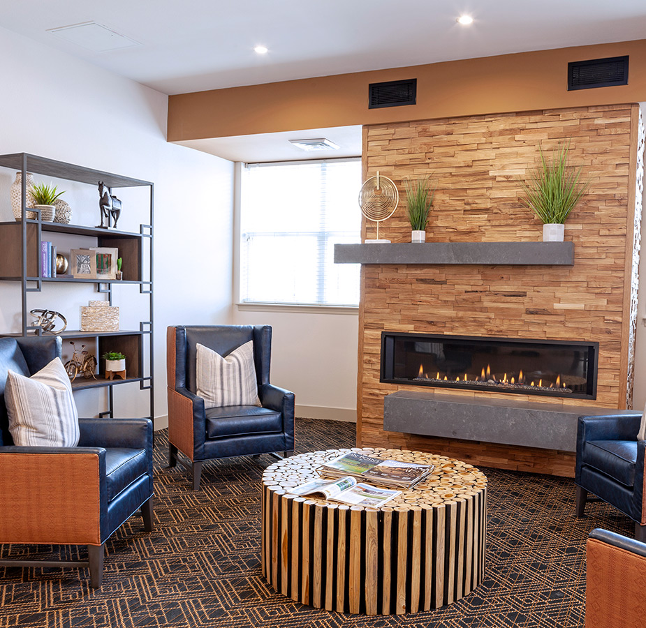A lobby seating area with chairs and a fireplace.