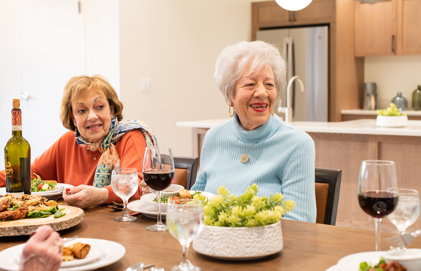 two women enjoying dinner and wine together
