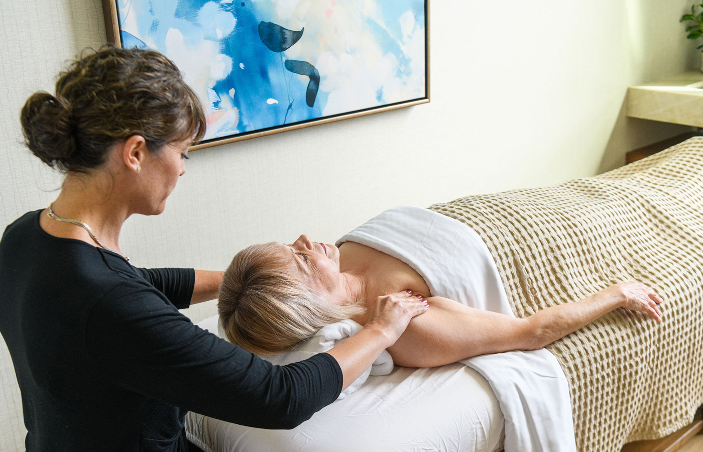 Woman gets massage by masseuse.