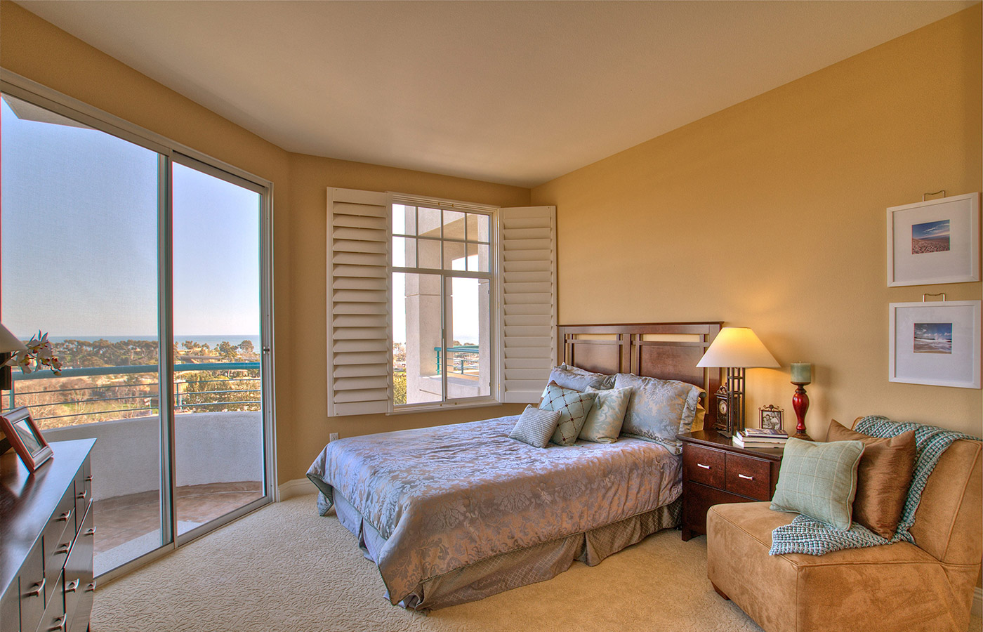 Furnished bedroom with bed, drawers, and soft lighting.