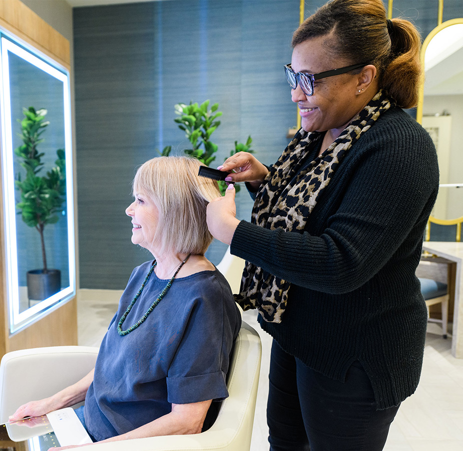 A resident is having their hair styled at a salon.