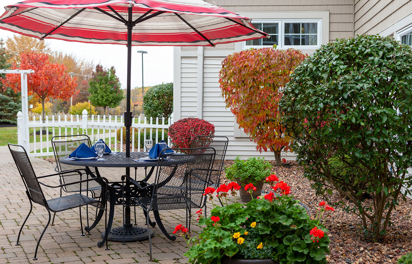 A patio with a table and chairs under an umbrella.