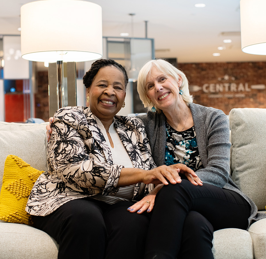 Two friends sitting together on a couch.