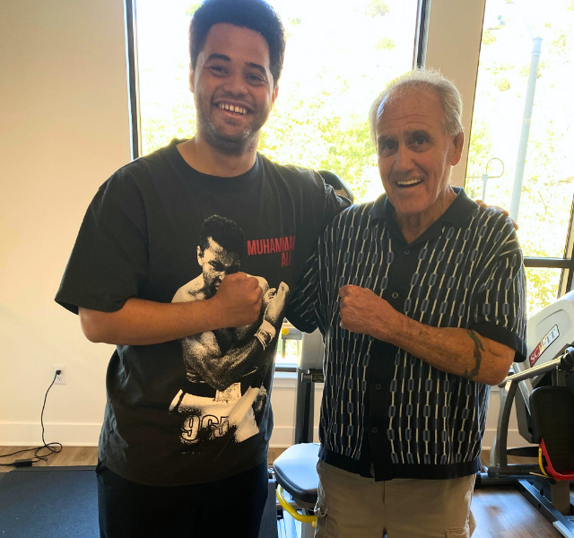 Boxing coach and resident smiling for the camera in the gym.