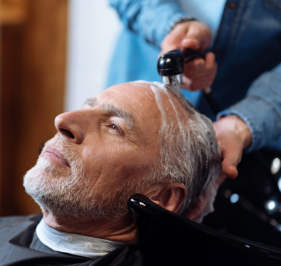 A resident is having their hair washed at the salon.