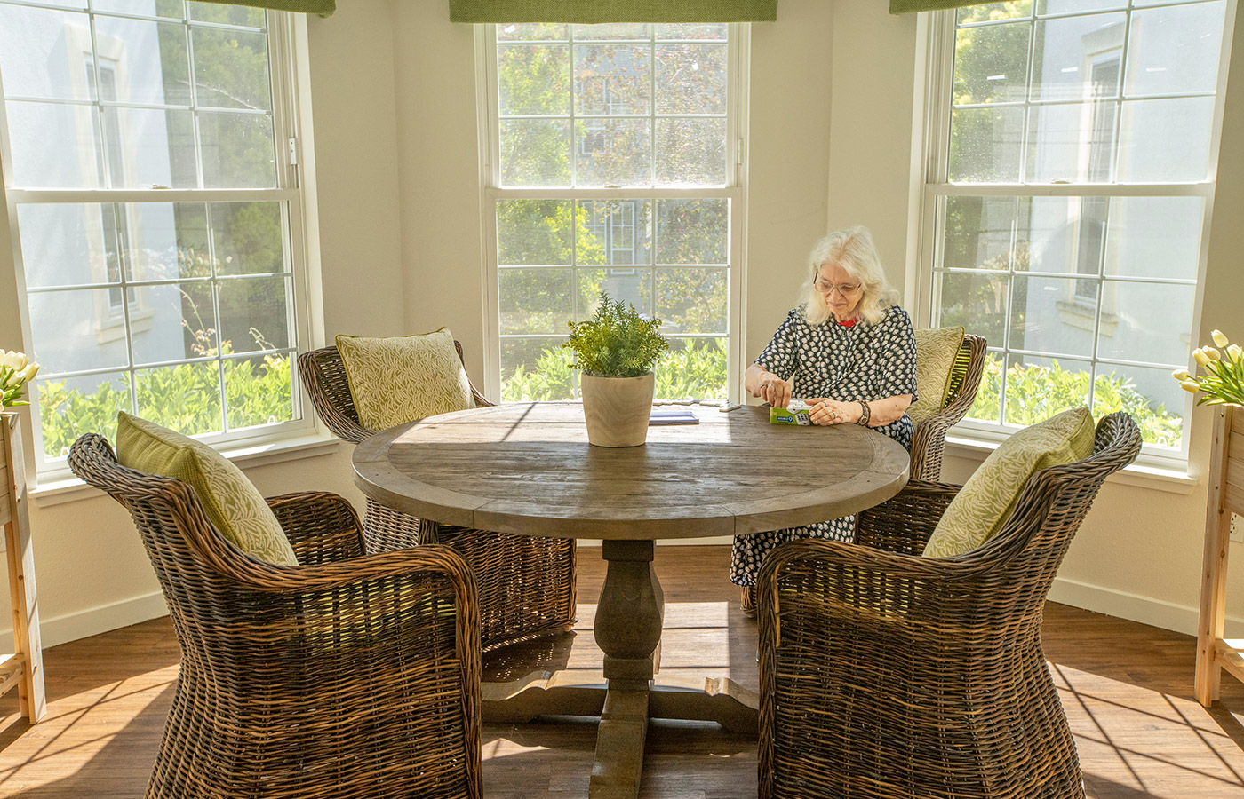 table and chairs in front of bright windows