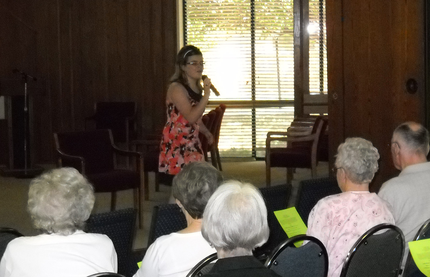 A teen singing for a group of people.