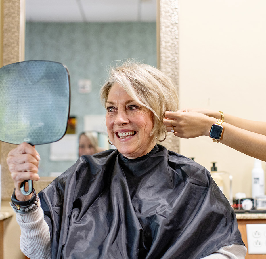 A resident is having their hair styled at a salon.