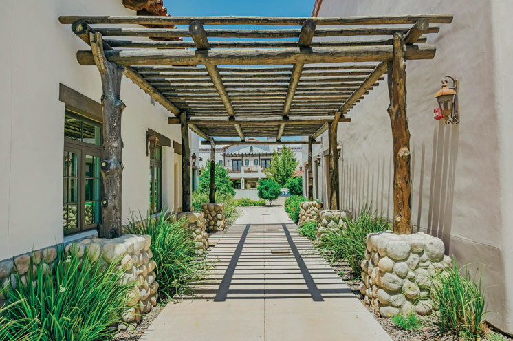 An outdoor pathway covered by a wooden terrace at The Hacienda at the River.