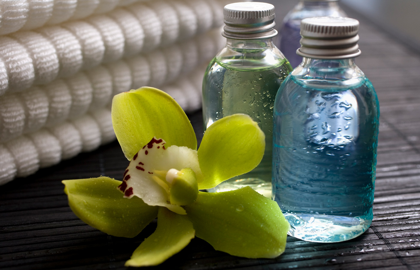 lily flower next to two glass spa bottles