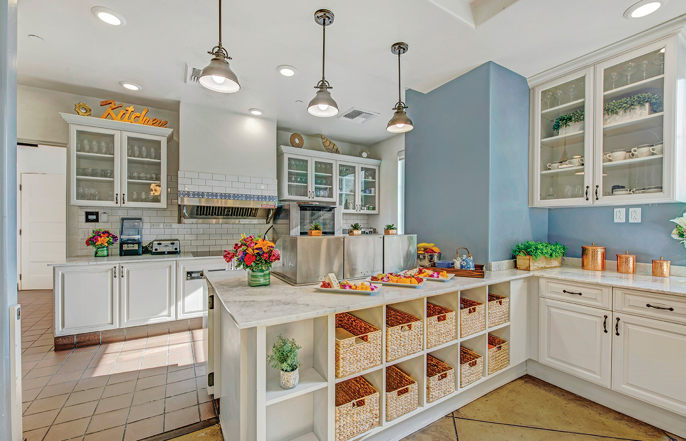 Kitchen with cabinets, island, sink, ceiling lamps and soft lighting.