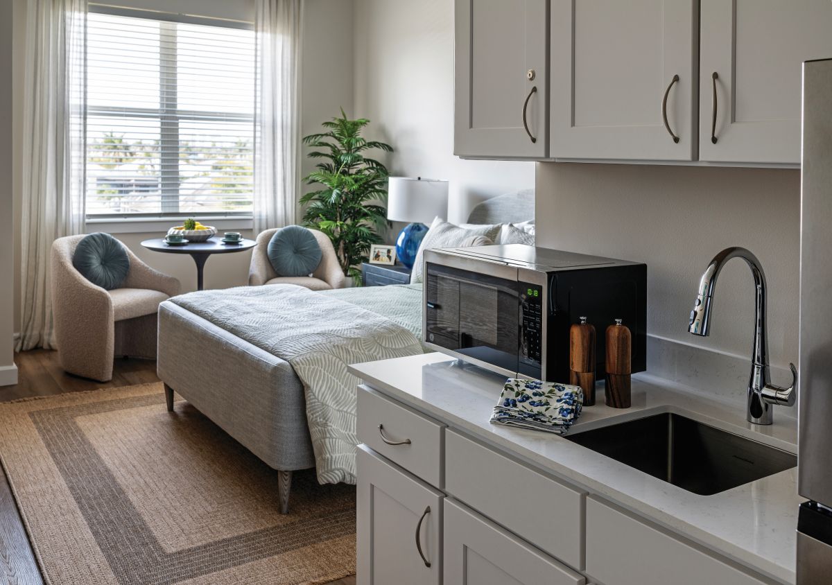 Studio apartment with a window, bed, and kitchenette.