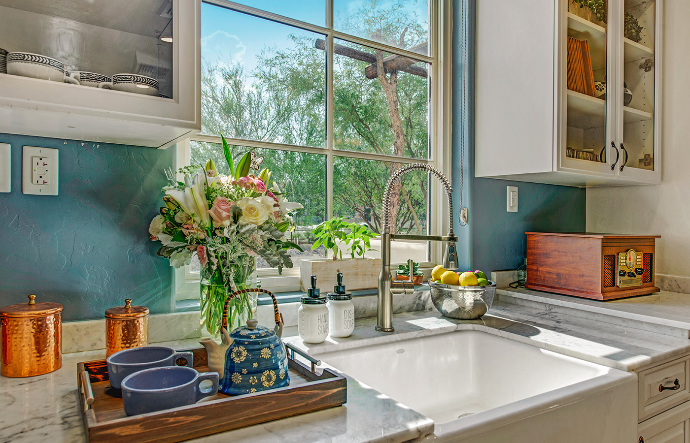 Kitchen counter with plates and sun shining through window.