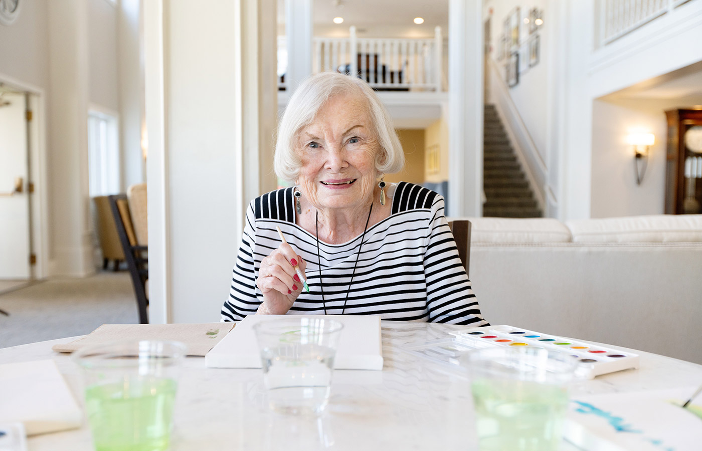 A resident is sitting at a table painting.