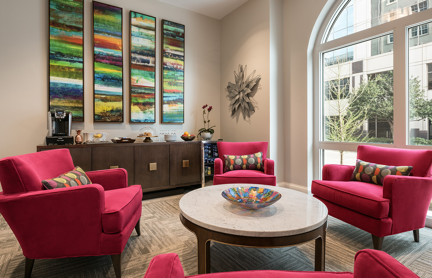Round coffee table surrounded by four colorful armchairs.  