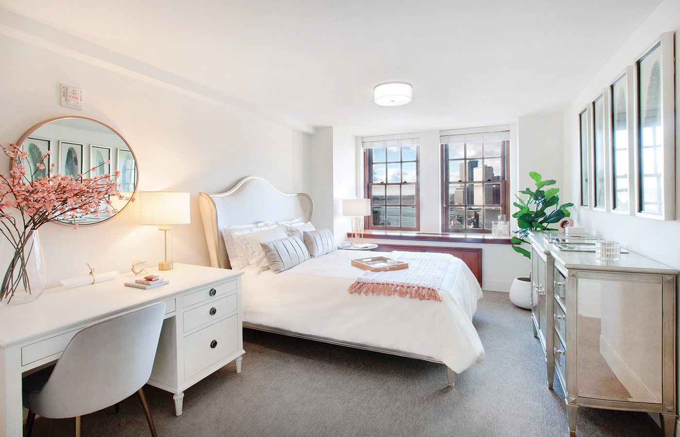 Furnished bedroom with bed, drawers, and soft lighting.