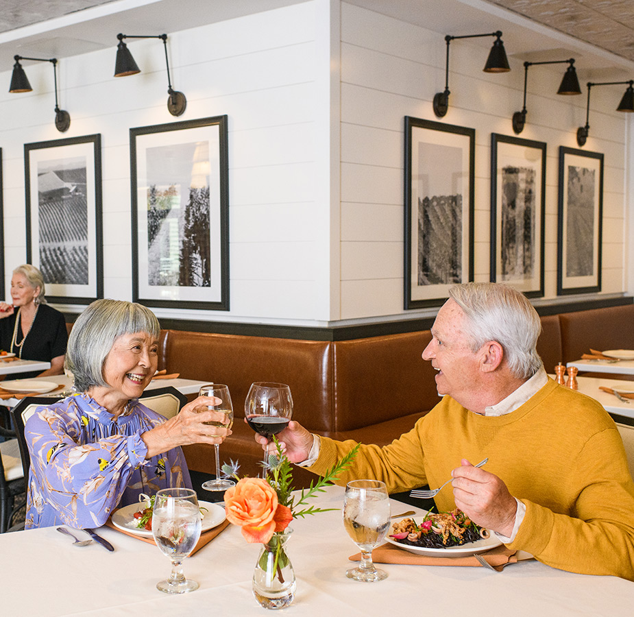 Two residents are having their meals together in the dining area at The Watermark at Napa Valley.