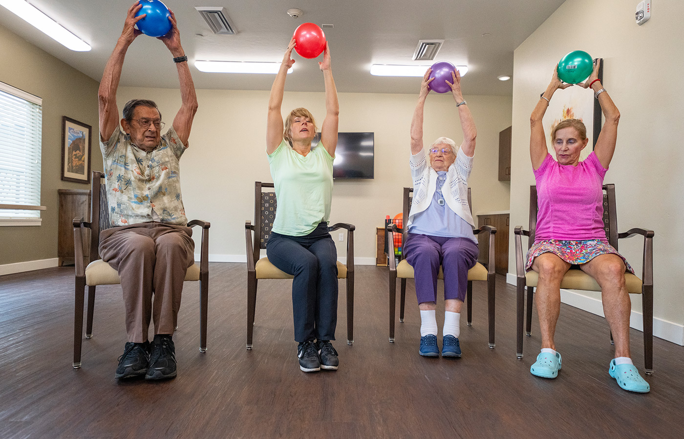 Residents holding balls above their heads in a fitness class