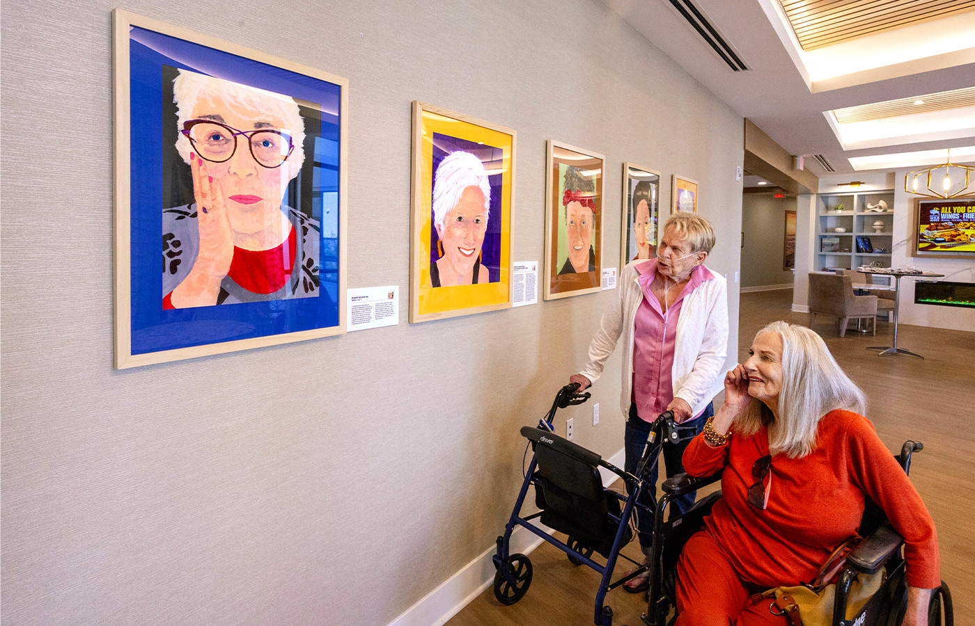 People looking at paintings on the wall.