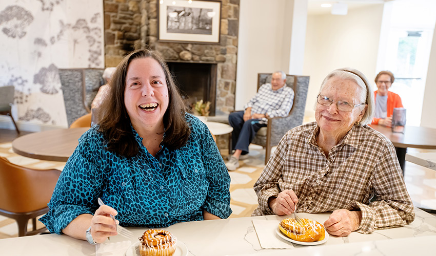 Two people eating pastries.