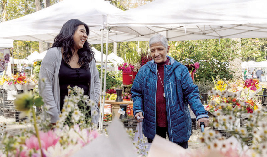 Two people are shopping at a farmers' market.