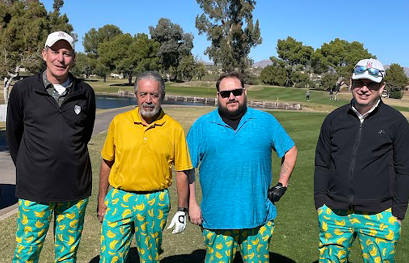 A group of people on the golf course with matching pants.